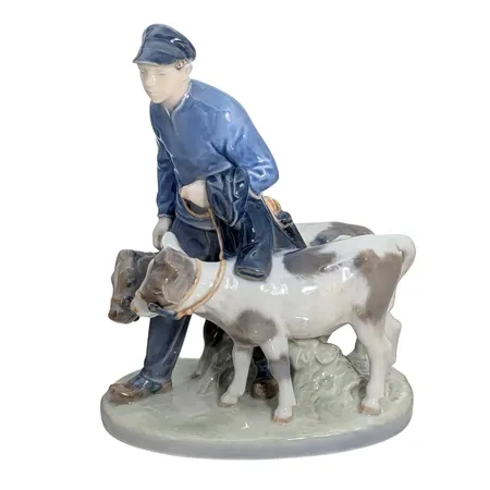 Figurin "Bonddräng med kalvar" nr 1858, porslin, KD - Kunglig Dansk/Royal Copenhagen, design Christian Thomsen, 1:a sortering, höjd 23 cm, längd 18 cm, bredd 11,5 cm, fint skick utan anmärkning, vikt omkring 1160 gram Skickas med paket.