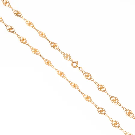 Colliér i 18K guld: Länkar med genombruten dekor. Det är 44 cm långt, 1,5 - 6mm brett och väger 4,6g. Dålig fjädring i springring. 