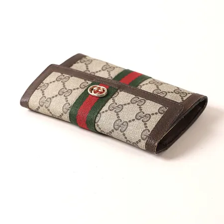 Plånbok, monogramcanvas och skinndetaljer, ca 10,5x3x16cm, slitage, skador/reva i läder, nötta kanter.