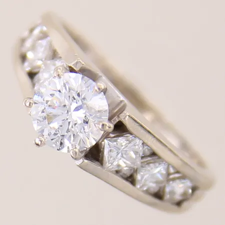 Ring med briljantslipad diamant ca 1,00ct, kvalitet ca W(H)/P samt 8 x ca 0,02ct, prinsesslipade 2 x ca 0,25ct, 2 x ca 0,16ct samt 2 x ca 0,12ct, stl 17¾, bredd 3-6,5mm, vitguld, ostämplat, 14K Vikt: 5,5 g