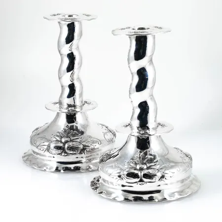 Ett par handcicelerade ljusstakar i silver. De är 18,5 cm höga och väger 568g. Fyllda i de vågiga "skaften" men ej i fötterna. Stämplade HANDCIC TESI, Göteborgs stadsstämpel, kattfot, S & C9 (1953).