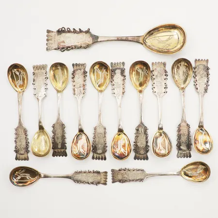 Tolv Kaffeskedar, längd 11,5cm, en dessertsked, längd 16cm, motiv av ren och same, silver 830/1000 Vikt: 181,9 g