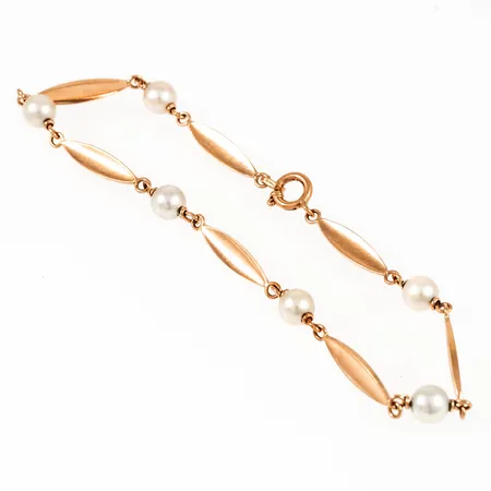 Armband i 18K guld med sex 4,5 mm´s odlade pärlor. Det är 19,5 cm långt, 3,1 mm brett och väger 4,9g. Springring.