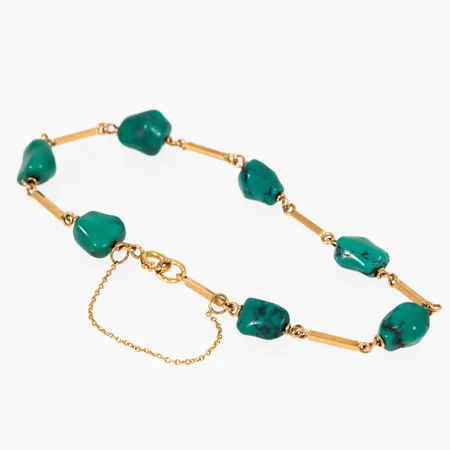 Stavarmband i 18K guld med sju turkoser. Det är 19,5 cm långt, 1,4 - ca 7 mm brett och väger 8,5g. Springring & säkerhetskedja. Oläsliga, svenska stämplar.