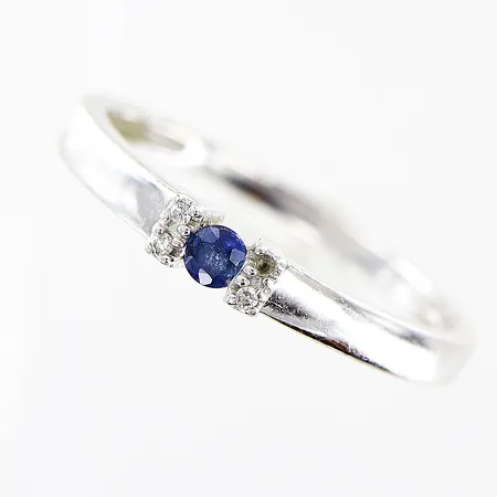 Ring, diamanter 3 x ca 0,005ct, blå sten, stl 17mm, bredd 1,5-2,8mm, 1 diamant saknas, vitguld, 14K. Vikt: 1,5 g