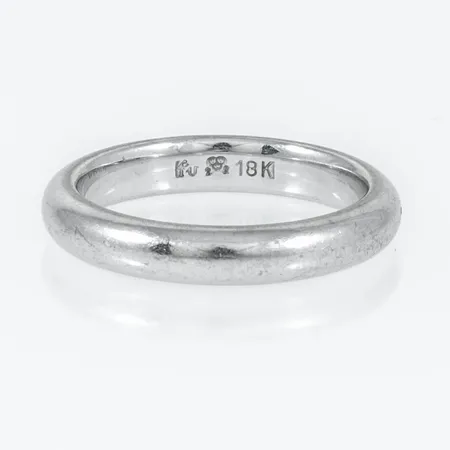 Slät ring i 18K vitguld. Den är i storlek 16¼, är 3,5 mm bred, 2,2mm hög och väger 5,5g. Stämplad FU (Flemming Uziel, Helsingborg), 18K och kattfot.