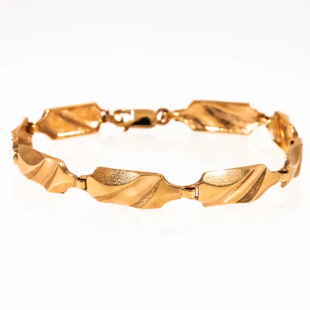 Vildmarksmönstrat armband i 18K guld. Det är 19,5 cm långt, 7,7 mm brett och väger 13,4g. Karbinhake. Stämplat BEH 18K 750.