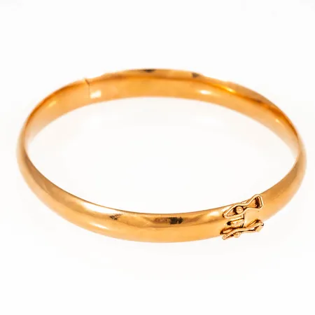 Stelt, öppningsbart armband i 18K guld. Det är 7 mm brett, har ett innermått på 17 cm och väger 8,1g. Istickslås och två säkerhetsåttor. ihålig modell- småbucklor.