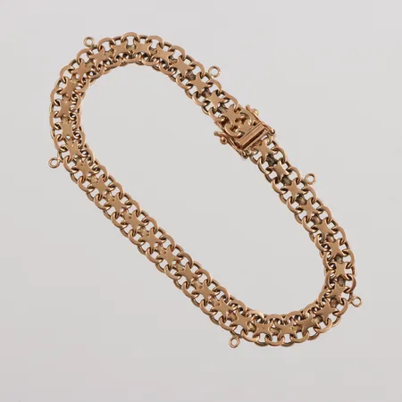Armband 18k X-länk,August Mikkov AB Stockholm,längd ca 20 cm,bredd 7.2 mm,6 st berlocköglor. Vikt: 16,9 g