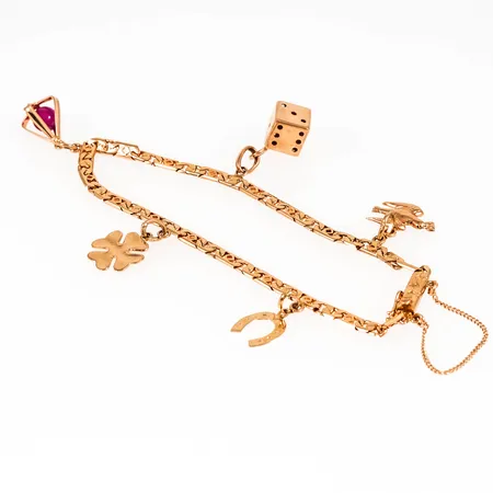 Armband i 18K guld med fem berlocker: Brevduva, tärning. Det är 18 cm långt, 3 mm brett och väger 9,6g. Kistlås, säkerhetskedja. gravyr på en berlock.