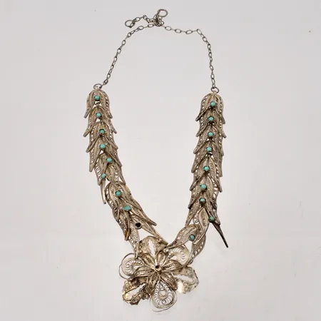 Collier i silver, 43,5cm, bredd 17,5mm, Fillergran arbete, 18st turkosa stenar, mått Ø2,7mm, 830/1000, varav en saknas, lås saknas, vikt 32,12g.