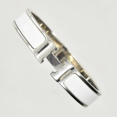 Armband Hermès Clic Clac H, vit metall med vit emalj, märkt Hermès Made in France FI 01 18,  innermått ca 58x42 m, bredd 11,5 mm, ytliga repor, inga tillbehör