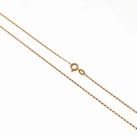 Kedja irrgång i 18K guld. Den är 47,5 cm lång, 0,6 mm bred och väger 2,1g. Springring.