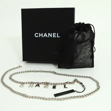 Bälte Chanel i silverfärgad metall med hängande bokstäver som bildar namnet Chanel, höjd 12,5mm, Pansarkedja bredd: 7,5mm, justerbar längd ca 103cm, CC logga, märkt Chanel made in France, etui. 