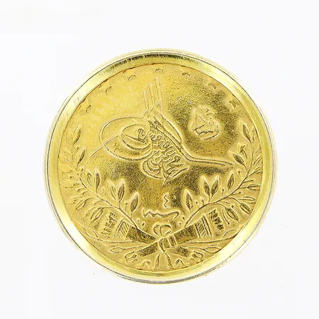 Mynt i 18K, Ø18mm, infattat i ram i 14K.  Vikt: 3,2 g