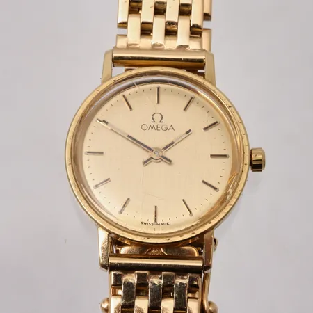 Damur Omega i 18K guld, Ø21mm, qvartz, länk i 18K guld, handledsmått inklusive ur 16cm, repor i glas, i behov av batteribyte, bruttovikt 35,4g, ca nettovikt 32g.