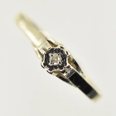 Ring med vit sten, stl 15½, bredd 2-4 mm, skev skena, vitguld, 18K. Vikt: 1,1 g