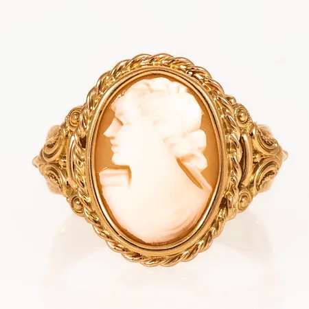 Ring i 18K guld med en vackert infattad camé. Den är 6 - 19 mm bred, är i storlek 18 och väger 7,3g. Gravyr.
