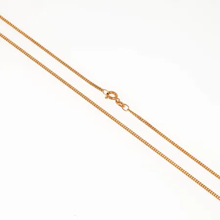 Kedja pansar i 18K guld. Den är 45 cm lång, 1,6 mm bred och väger 4,5g. Springring.