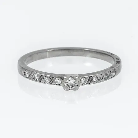 Ring i 18K vitguld med en briljantslipad diamant ca 0,05ct & 8 x ca 0,01ct 8/8-slipade diamanter.  Den är 1,9 - 3 mm bred, är i storlek 18¼ och väger 2,7g. 