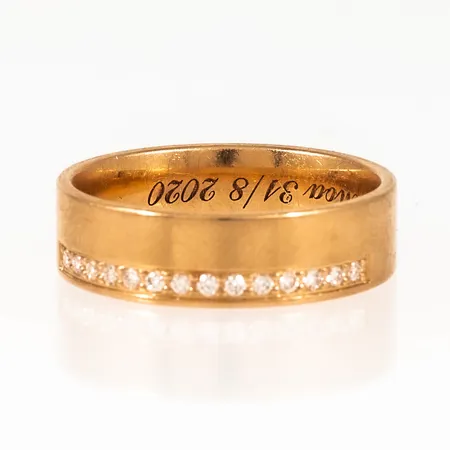Ring i 18K guld med diamanter 14 x 0,01ct. Den är 6 mm bred, är i storlek 18¾ och väger 6,9g. Från Schalins. Kupad insida. Gravyr. 