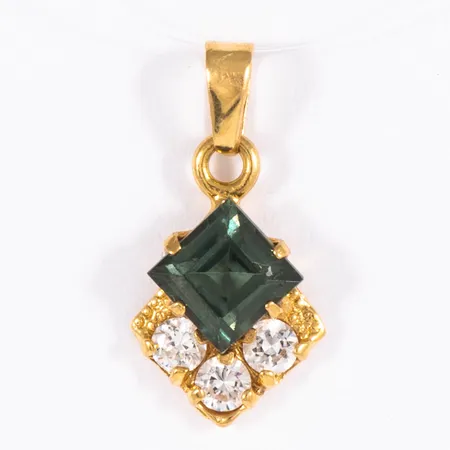 Hänge i 18K guld med en grön och tre vita stenar. Det är 8,5 mm brett, 17 mm långt inkl. ögla och väger 0,7g. Stämplad SGS (Svenskt Guldsmide AB, Stockholm), 750.