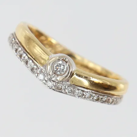 Ring med briljantslipade diamanter totalt 0,20ctv enligt gravyr, stl: 16, bredd 2,7-5,5mm, gravyr, tvåfärgat 18K. Vikt: 2,6 g