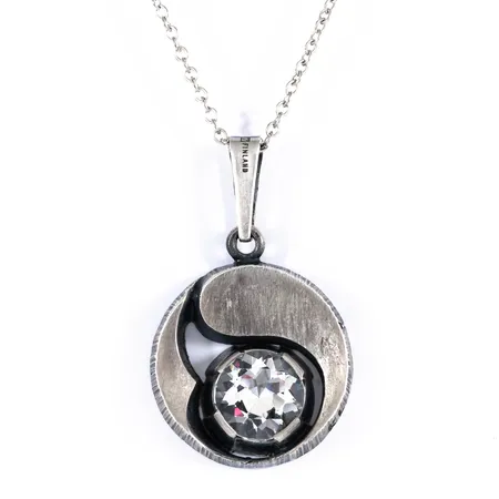 Hänge i lätt oxiderat silver (925/1000) med bergkristall. Karl Laine för Finnfeelings, Finland. Det är Ø 22,5 mm och väger 8,7g inkl. kedja 60 cm.