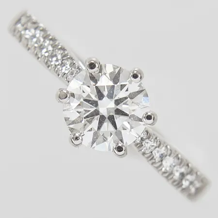 Ring med syntetiska diamanter 1 x 1,01ct, D/VS1 enligt certifkat från IGI samt 14 diamanter 0,14ctv enligt gravyr, Ø16½, bredd: 2,4-7,6mm, ograverad, laserinskription: IGI LG529262028, GHA, 18K, certifikat samt etui medföljer Vikt: 4,2 g