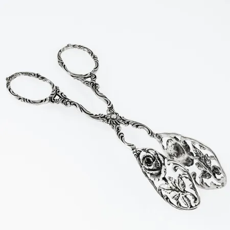 Kaktång i silver (830/1000) med rosdekor. Den är 13 cm lång och väger 28,0g.