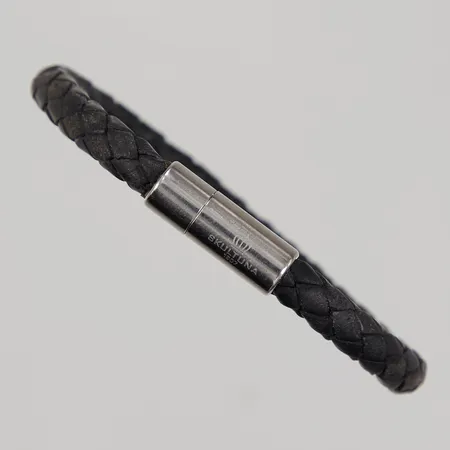 Armband flätat svart läderband, 19cm, lås i vitmetall, Skultuna 1607.