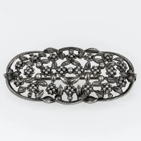 Brosch i silver (830/1000) med genombruten organisk dekor. Det är 48 x 23 mm och väger 7,5g.