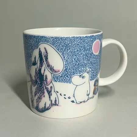 Mugg Mumin Vintermuggen från 2019 Djupsnö / Crown Snow-load, Design Tove Slotte ville uppmärksamma Tove Janssons enastående förmåga att illustrera naturen, stämplad by Arabia, porslin, Höjd 8 cm, Ø8,5 cm, rymmer 0,3L. Snr: CR0419 Skickas med paket.