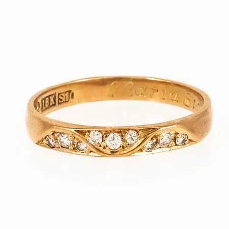 Ring i 18K guld med 9 briljantslipade diamanter totalt 0,12ct. Den är i storlek 17, är 2,5 - 3 mm bred och väger 2,1g. Stenstorlek 0,12ct ingraverat. Gravyr.