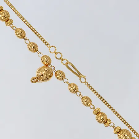 Collier med dekor av kulor, längd 41-42cm, bredd 2-10mm, 21K. Vikt: 15,1 g