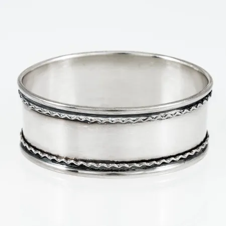 Servettring i silver (830/1000). Mått 49,5 x 37,5 mm. Vikt: 16,4g. Stämplad T9 (1969), K&EC (Ceson Guldvaru AB, Göteborg), S och kattfot.