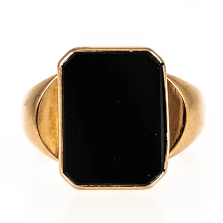 Klackring i 18K guld med svart sten (onyx). Den är i storlek 19½, är 3,5 - 16,5 mm bred och väger 5,0g. Något skev skena, sprickor i fattning.