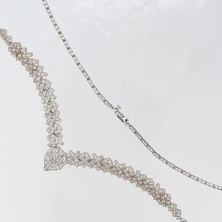 Collier med diamanter ca 187 x ca 0,02-0,03ct, totalt ca 4,70ctv, enstaka diamanter indikerar på syntetiska, längd 45cm, bredd 2,2-15,5mm, vitguld 18K. Vikt: 21,7 g