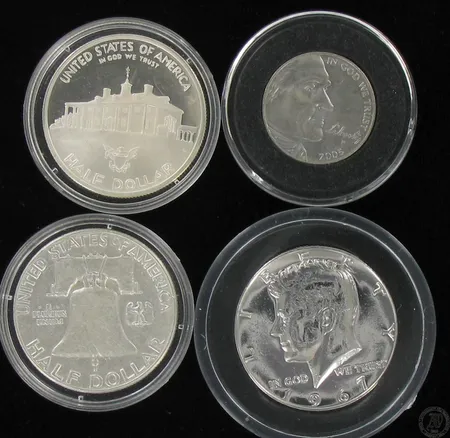 Neljä hopearahaa USA, kolme half dollar, vuodelta 1961, 1962 ja 1982, yksi five cents, vuodelta 2005.