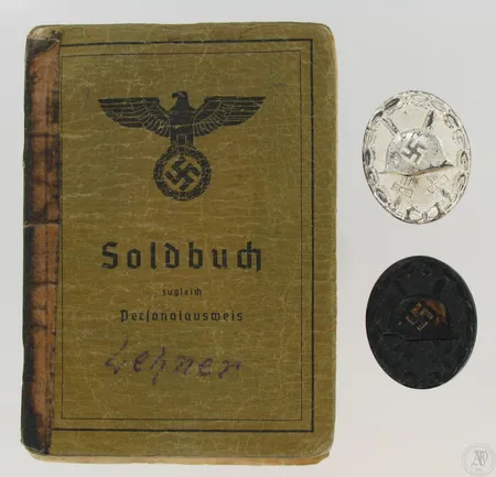 Kaksi mitalia, Saksa Haavoittumismitali hopea ja musta, annettu Suomen Lapissa haavoittumisesta 1941. Mukana sotilaspassi, jossa merkintä myönnöstä.