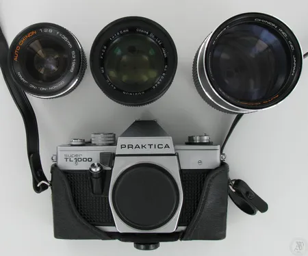 Kameranrunko Praktica Super TL1000 ja kolme objektiivia: Chinon IND., INC. Japan, Auto Chino 1:2.8; Cosinon Auto MC F=2.8, No.604645; Auto Chinon 1:3.5 f=200mm 516231, omassa laukussa.