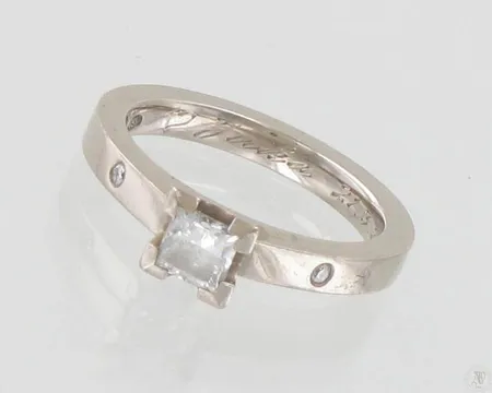 Timanttisormus 1xn.0.40ct (Princess) 2xn.0.01ct, kaiverrettu, koko 15¾, tekijäleima U.Tarkkanen, 750 valkokulta, paino 5,3g Paino: 5,3 g