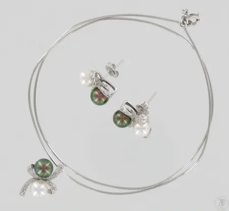 Helmikorvakorut ja helmikaulakoru timanteilla 30xn.0.005ct, ketju hieman vääntynyt, pituus 40cm, korvakorujen ja riipuksen korkeudet 17-20mm, 750br valkokulta, paino 10,6g Paino: 10,6 g