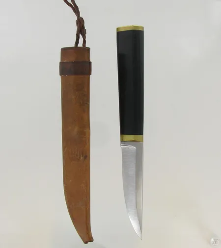 Puukko, design Tapio Wirkkala, ruostumatonta terästä, nailonia ja messinkiä, nahkatuppi