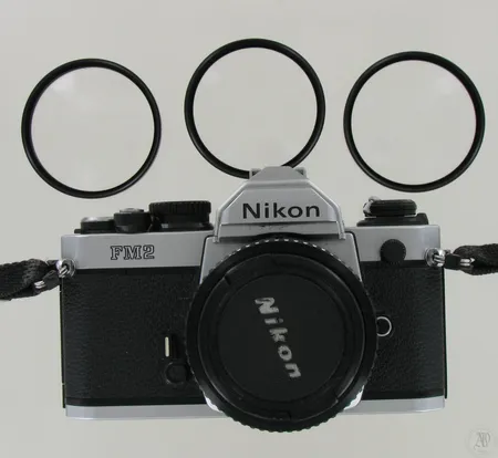 Filmikamerarunko Nikon FM2, objektiivi Nikon Nikkor 50mm 1:1.8 2257829, mukana 3 loittorengasta: Soligor 52mm +1, +2 ja +3, käytön jälkiä.