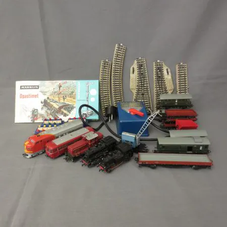 Pienoisrautatie Märklin, viisi veturia, yhdeksän vaunua, kolme vaihdetta, nosturi, opasteita, seitsemänkymmentäyksi raideosaa, muuntaja, liittimiä, tarvikkeita, opaskirja