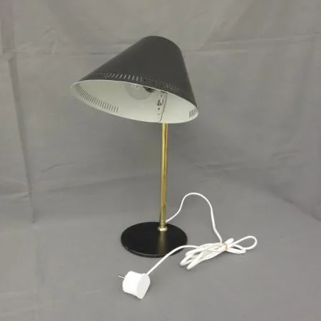 Pöytävalaisin Idman, valmistaja Taito Oy, malli 9227, käytön jälkiä, design Paavo Tynell, korkeus 43cm, mustaksi maalattua metallia ja messinkiä, toimii. Ainoastaan nouto myymälästä.