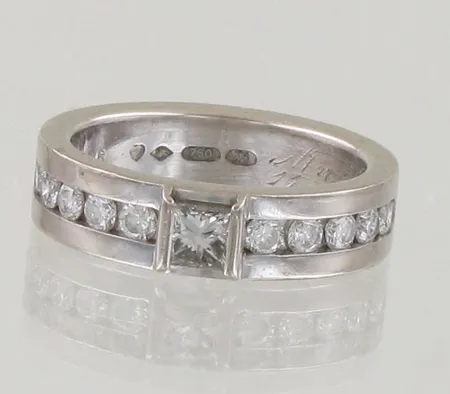 Timanttisormus 1xn.0.22ct princess-hiontainen ja 10xn.0.04ct, kaiverrettu, koko 16, tekijänleima AT, vuodelta 1999, 750 valkokulta, paino 7,6g