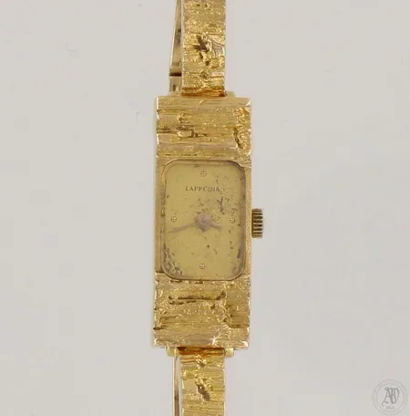 Kultarannekello Lapponia, deisgn Björn Weckström, vuodelta 1984, quartz, taulun kultauksessa kulumaa, taulun mitat 11x30mm, rannekkeen pituus 180mm, 750br, paino 30,2g