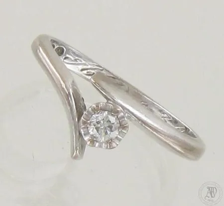 Timanttisormus 1xn.0.08ct, kaiverrettu, runko hieman vääntynyt, koko 15½, 750 valkokulta, paino 2,9g
